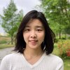 Headshot of Hwang in a white shirt against nature.