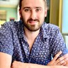 Grad student Patrick Kimutis smiles at the camera with crossed arms